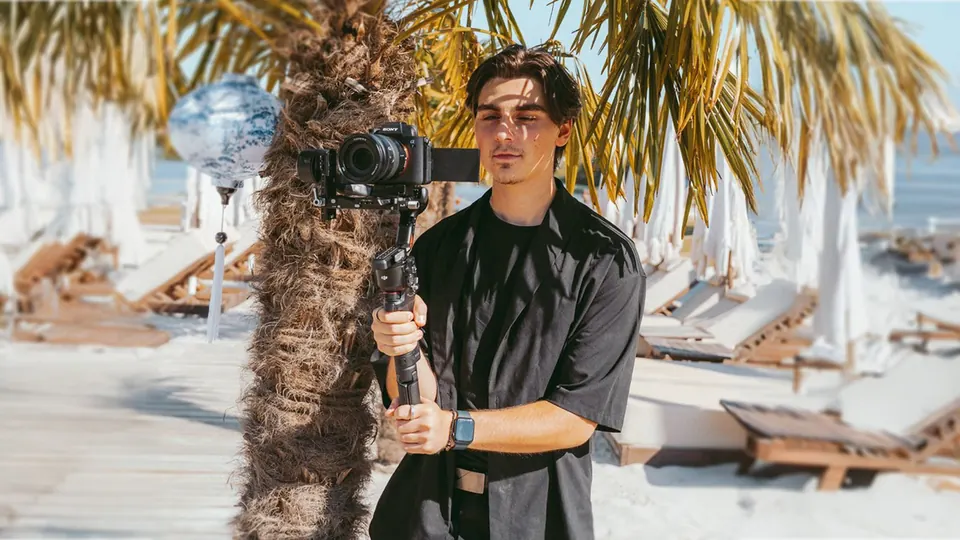 Videograf Nikolas Ortmann mit Kamera und Gimbal am Strand